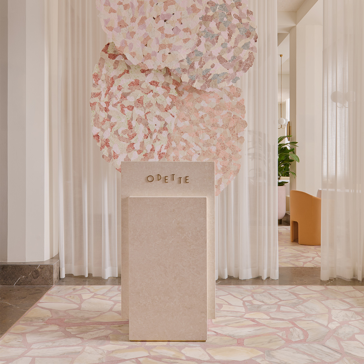 Odette-Elegant café entrance with a sculptural installation and soft interior décor.
