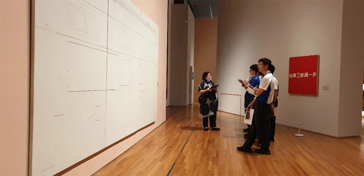 Students from Nan Chiau High School standing in front of Alphabet Skin No. 3 by Arakawa Shūsaku on a docent-guided tour of Awakenings: Art in Society in Asia 1960s–1990s.