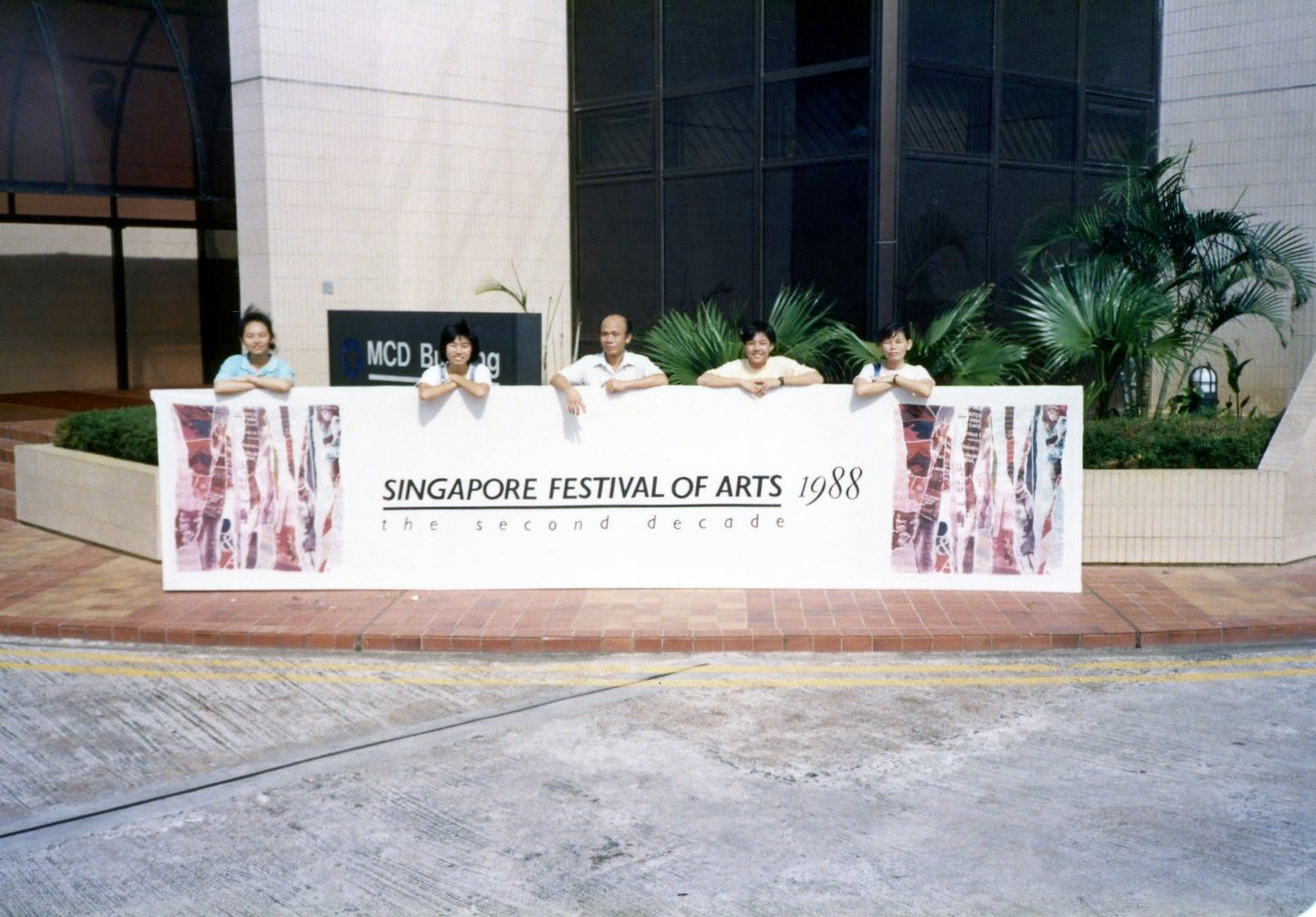 Ai Liang with colleagues posing with a banner for Singapore Festival of Arts, 1988