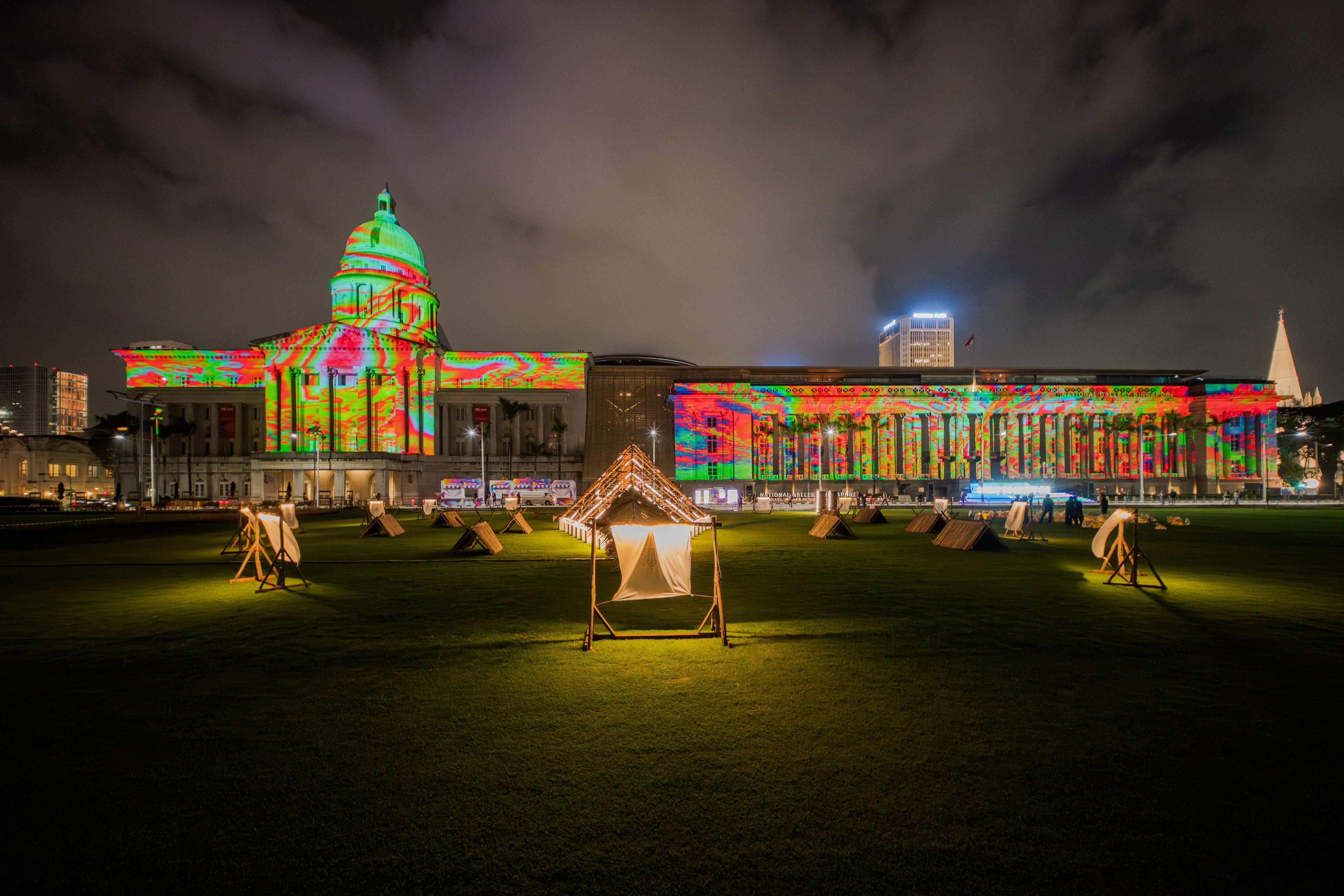 Nighttime scene of classical building illuminated with colorful light projections during Light to Night festival